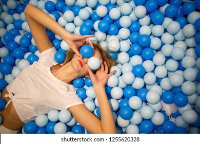 Young woman playing with balls in a dry pool