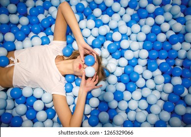 Young woman playing with balls in a dry pool