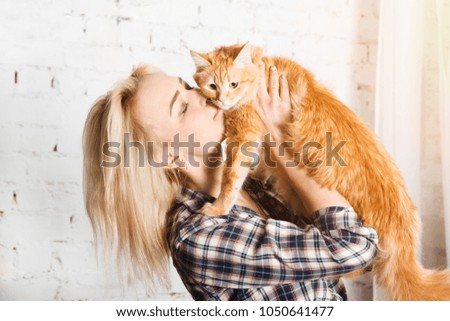 Young woman playing with cat in home.