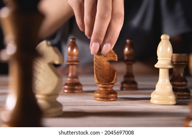 Young Woman Playing Chess Alone