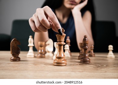 Young Woman Playing Chess Alone