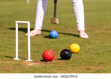 A Young Woman Is Playing Croquet On A Lawn