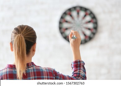 Young Woman Playing Darts Indoors