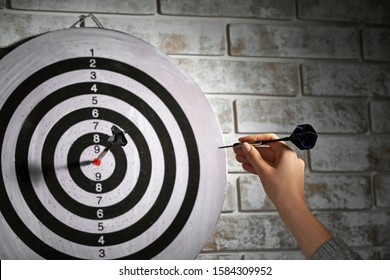 Young woman playing darts indoors - Shutterstock ID 1584309952