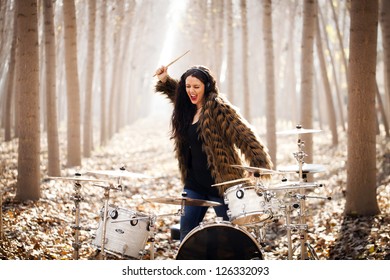 Young Woman Playing Drums Outdoors.