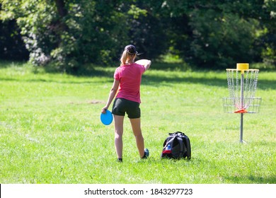 Young Woman Playing Flying Disc Golf Sport Game In The City Park Or Nature