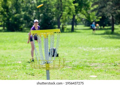 Young woman playing flying disc sport game in the park