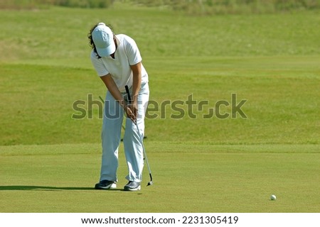 young woman playing golf on golf course in white dresses