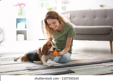 Young Woman Playing With Her Dog At Home