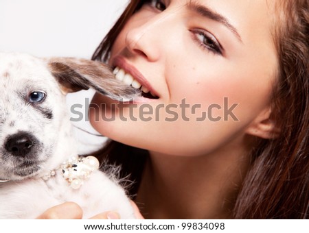 young woman playing with her puppy, close up portrait