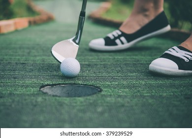 Young Woman Is Playing Mini Golf. Toned Picture