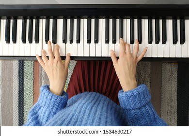 Young Woman Playing Piano At Home, Top View
