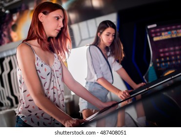 Young Woman Playing Pinball In Game Room