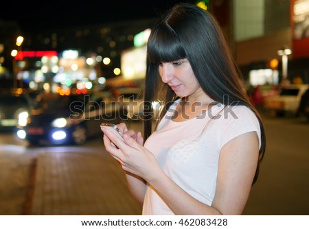 Young woman playing popular smartphone game in mall