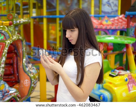 Young woman playing popular smartphone game in mall