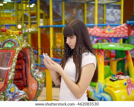 Young woman playing popular smartphone game in mall