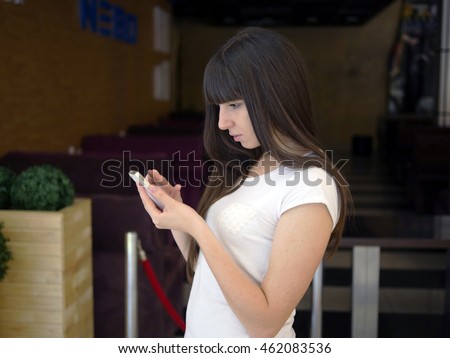 Young woman playing popular smartphone game in mall