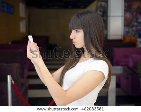 Young woman playing popular smartphone game in mall