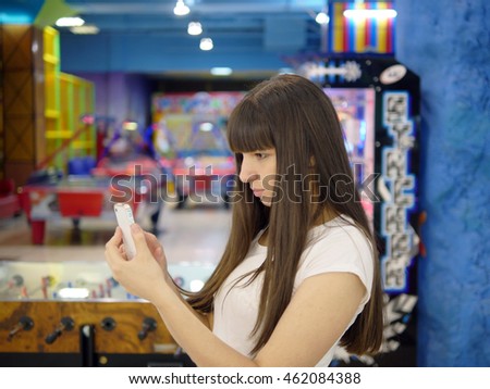 Young woman playing popular smartphone game in mall