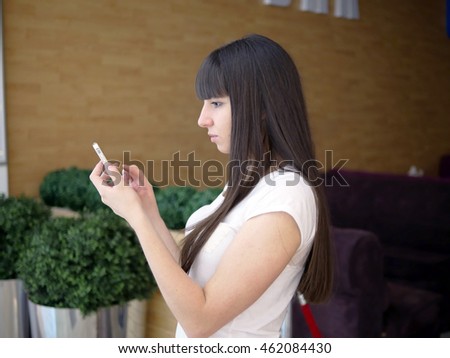 Young woman playing popular smartphone game in mall