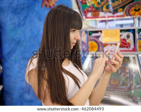 Young woman playing popular smartphone game in mall