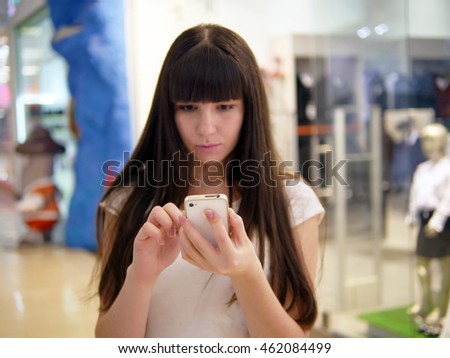 Young woman playing popular smartphone game in mall