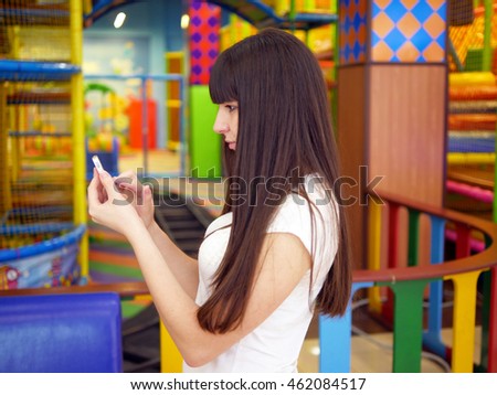 Young woman playing popular smartphone game in mall