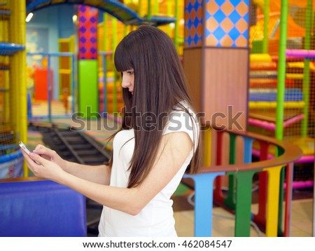 Young woman playing popular smartphone game in mall