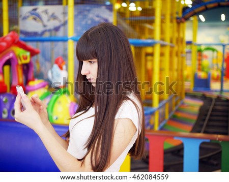 Young woman playing popular smartphone game in mall