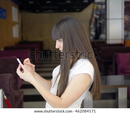 Young woman playing popular smartphone game in mall