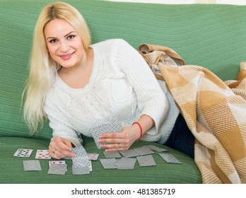 Young Woman Playing Solitaire At Domestic Interior