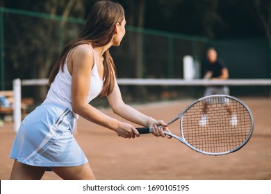 Young woman playing tennis at the court - Powered by Shutterstock