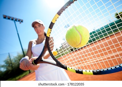 Young Woman Playing Tennis On A Sunny Day