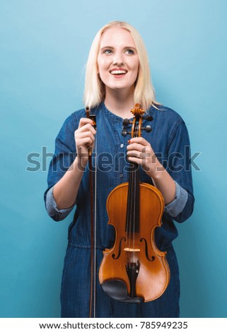 Young woman playing a violin on a solid background