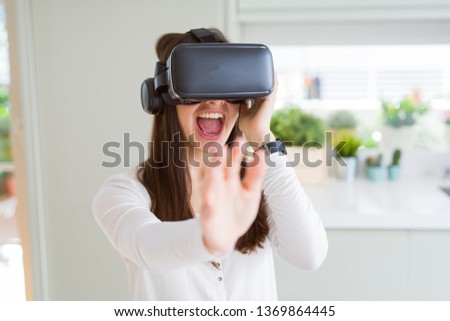 Young woman playing virtual reality game using simulation glasses headset, funny and amazing entertainment