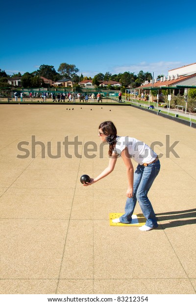 young woman plays lawn bowling in the\
afternoon (queensland,\
australia)