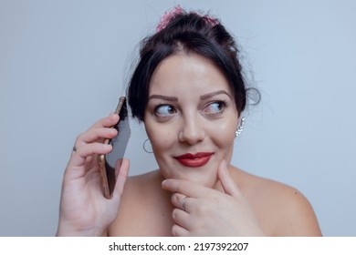 Young Woman Pleasantly Suprised Holding Phone Looking Aside