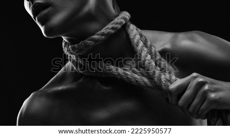 A young woman plucks ropes from her body and neck. Photo in black and white