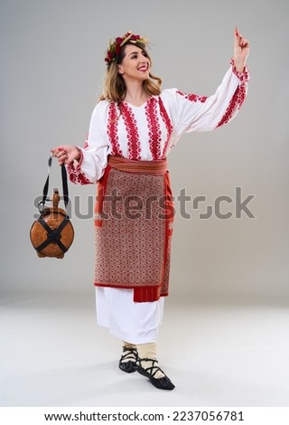 Young woman in popular vintage traditional Romanian costume, isolated on gray background