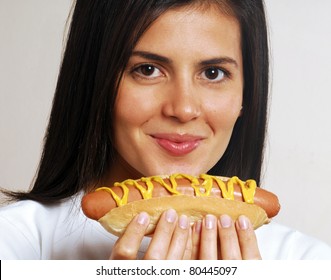 Young woman portrait eating a hotdog.