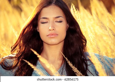 Young Woman Portrait With Eyes Closed Enjoy In Autumn Sun On Yellow Field