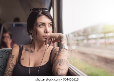 Young Woman Portrait Inside A Train Looking Out Of The Window. Lifestyle Concept.