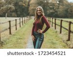 young woman posing between two willows on a dirt road