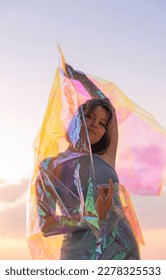 Young woman posing with holographic foil against sunset sky. Dreamy self expression concept fashion portrait - Shutterstock ID 2278325533