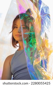 Young woman posing with holographic foil against sky. Dreamy self expression concept fashion portrait - Shutterstock ID 2280055425