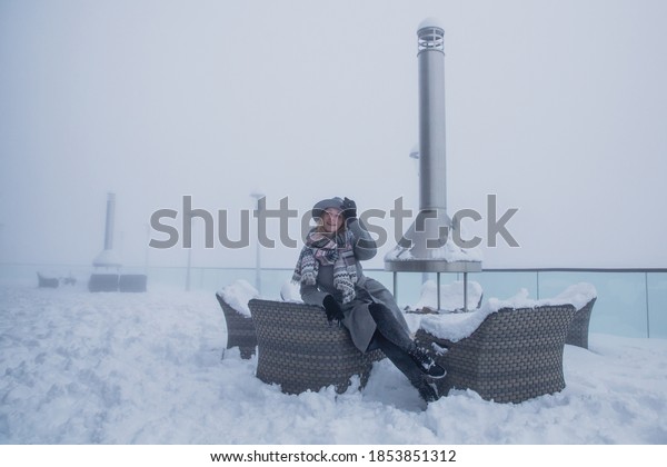 A\
young woman posing in a restaurant covered with snow at the cable\
car station, the mountain Tufandag, Gabala, Azerbaijan\
