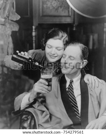 Young woman pouring beer into a man's glass, 1933. Photo was created in response to the legalization of beer with an alcohol content of 3.2% when President Franklin Roosevelt signed the Cullen_Harriso