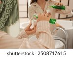 Young woman pouring mouth rinse in bathroom, closeup