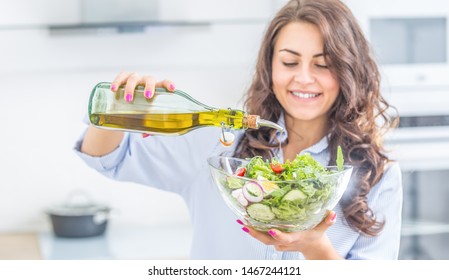 Young woman pouring olive oil in to the salad. Healthy lifestyle eating concept. - Powered by Shutterstock