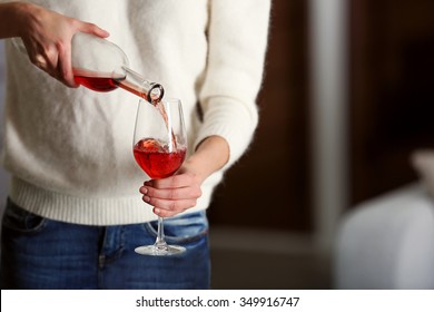 Young woman pouring pink wine into glass on blurred background - Shutterstock ID 349916747